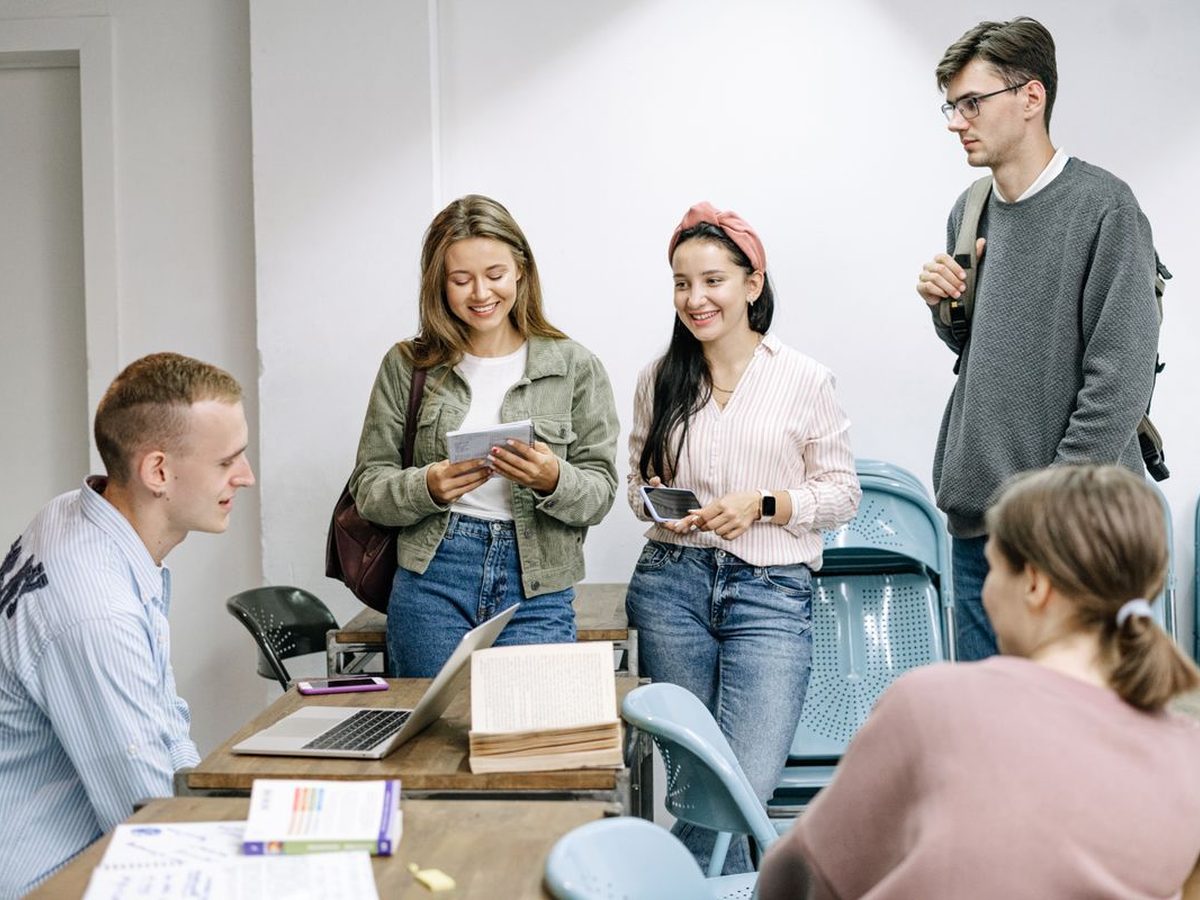 A group of students in a seminar room, one standing to speak